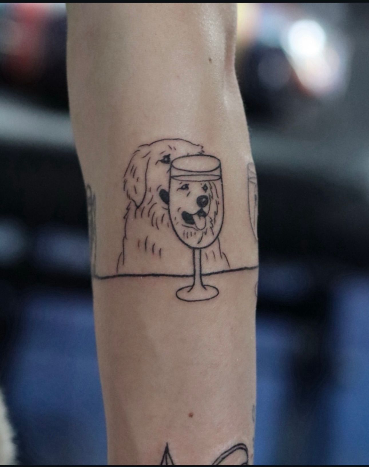 A tattoo of a dog and a glass of wine