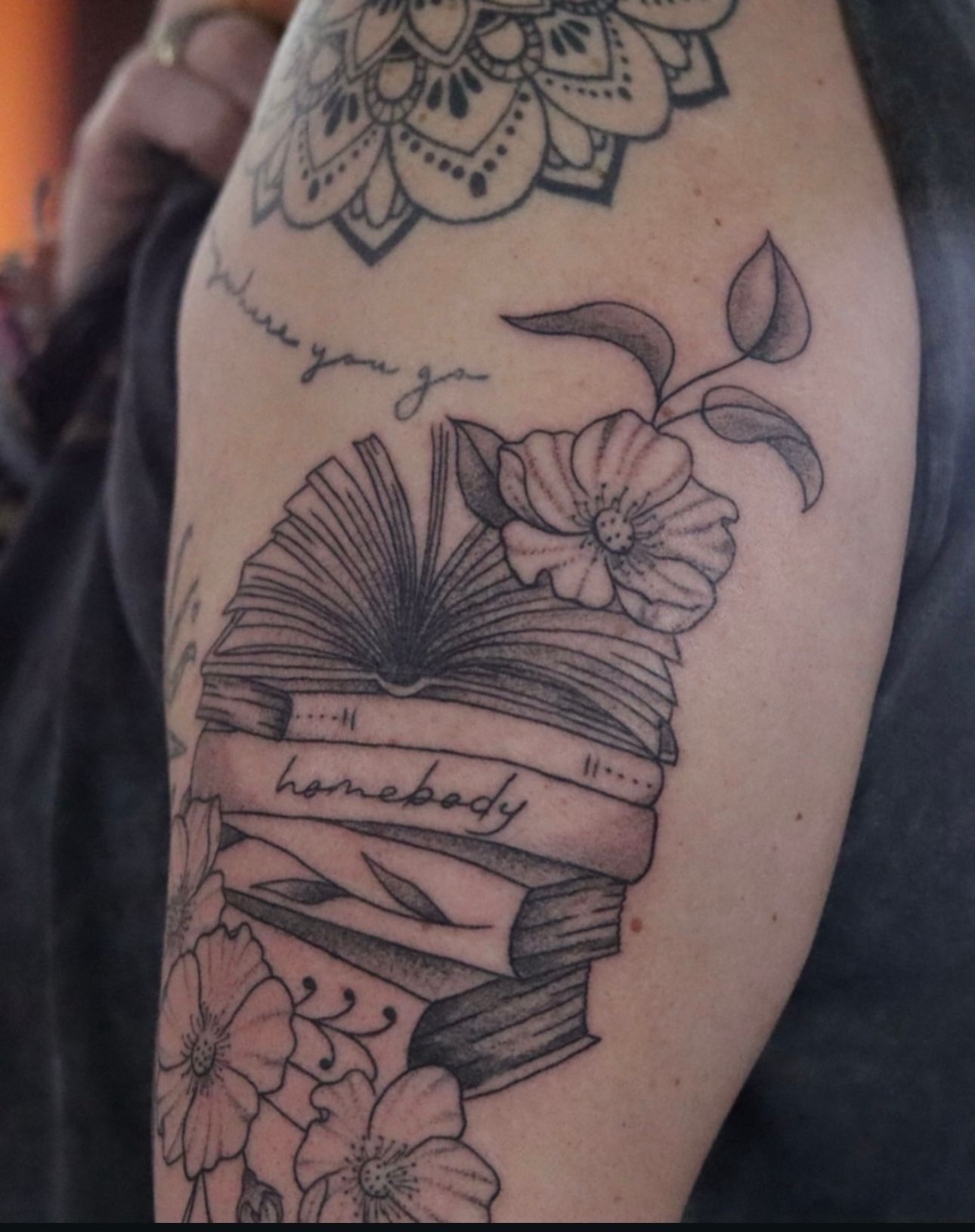 A tattoo on a person 's arm that says homebody