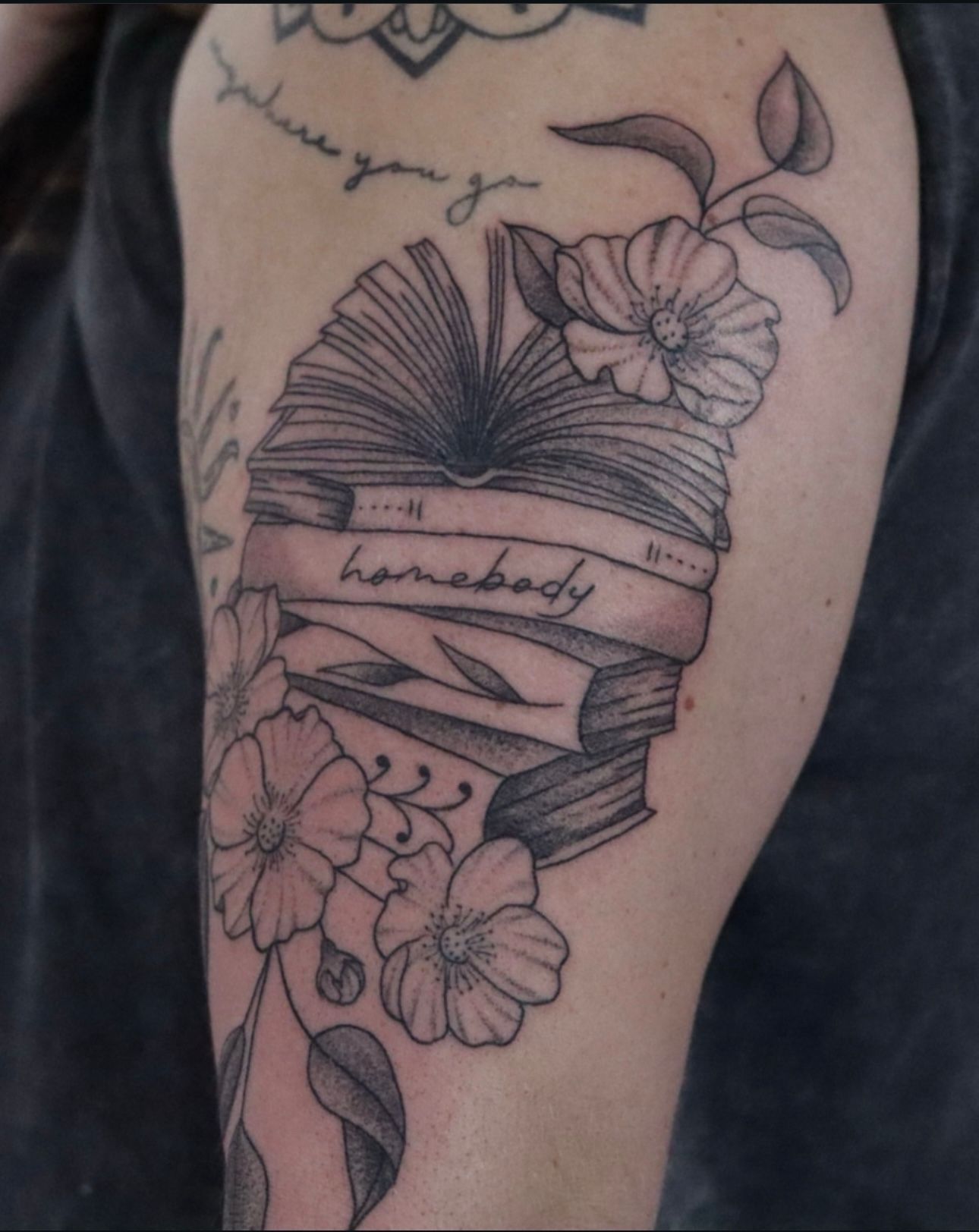 A tattoo of a stack of books with the word homebody on it