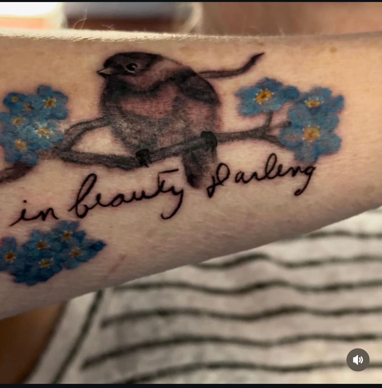 A tattoo of a bird on a branch with the words in beauty darling