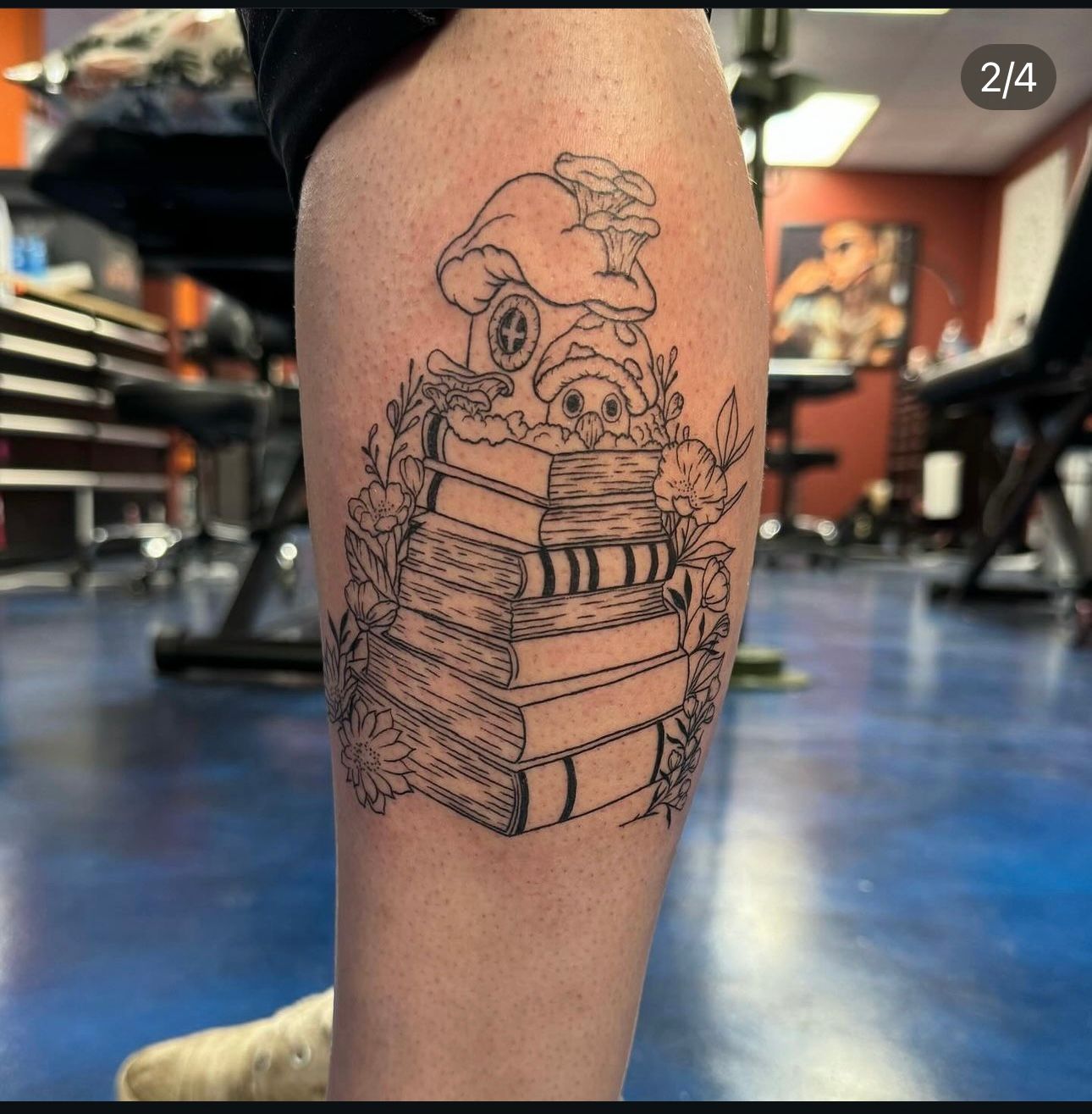 A tattoo of a stack of books on a person 's leg