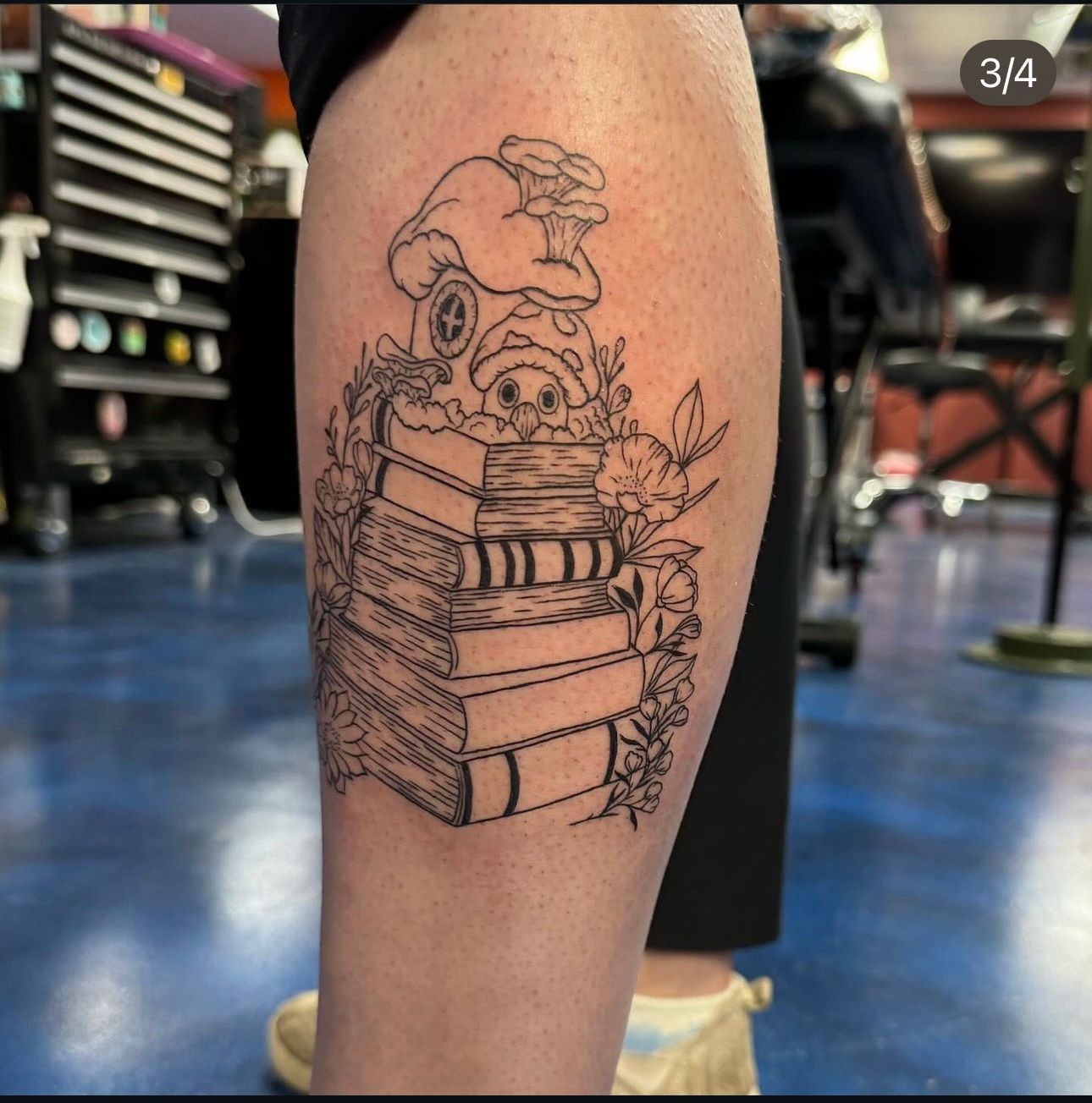 A tattoo of a stack of books on a person 's leg