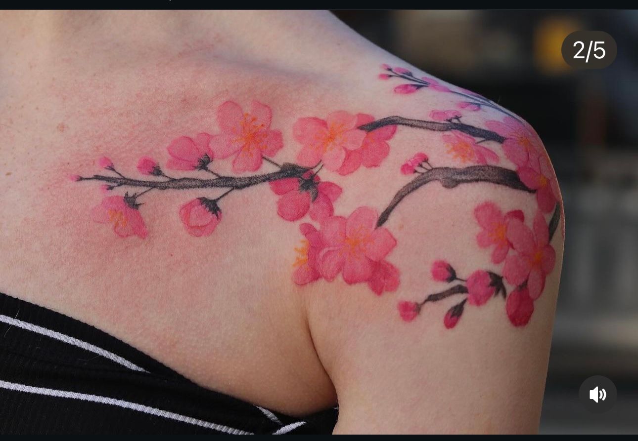 A woman has a tattoo of cherry blossoms on her shoulder