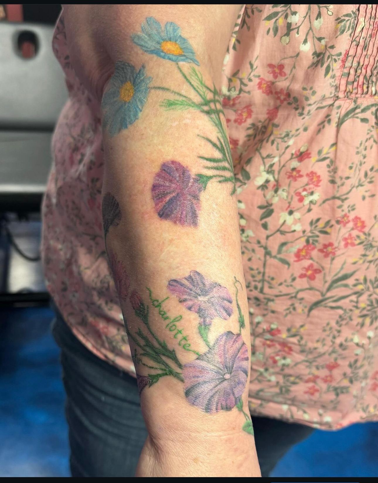A woman has a tattoo of flowers on her arm.