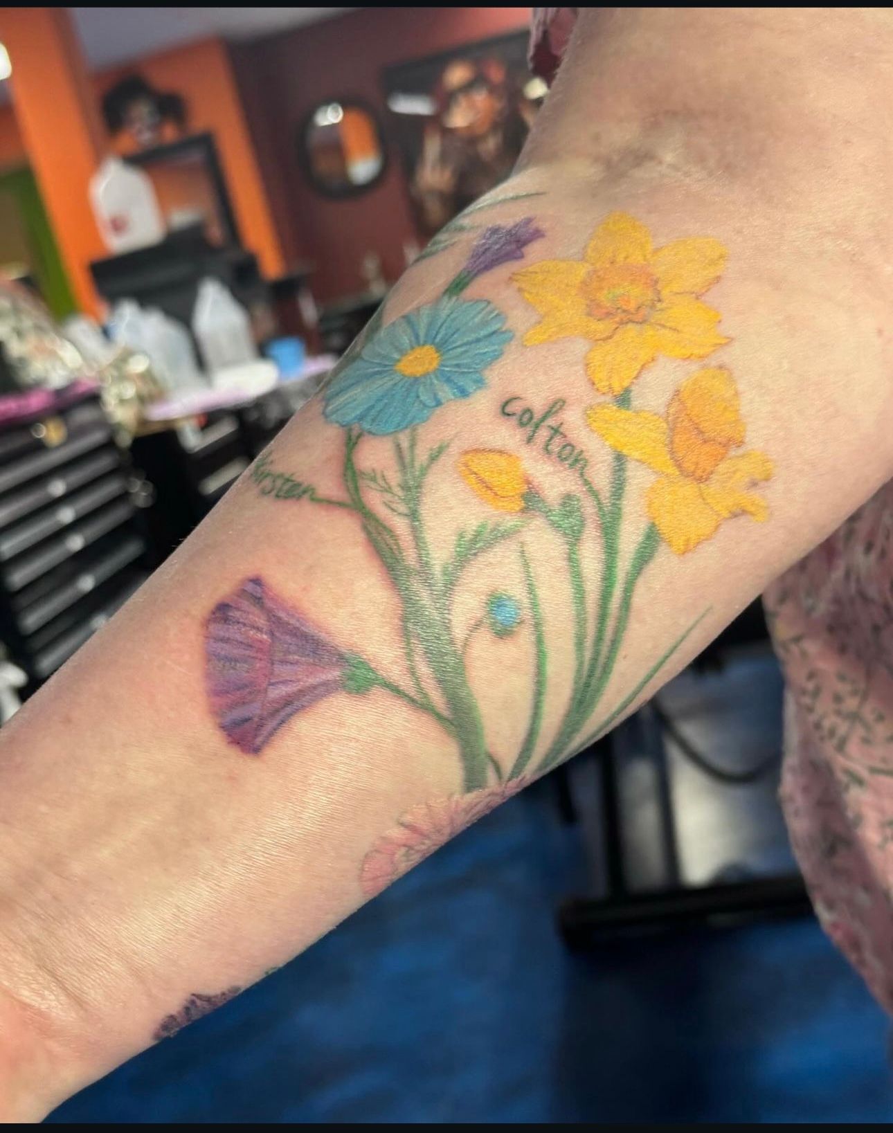 A person has a tattoo of flowers on their forearm