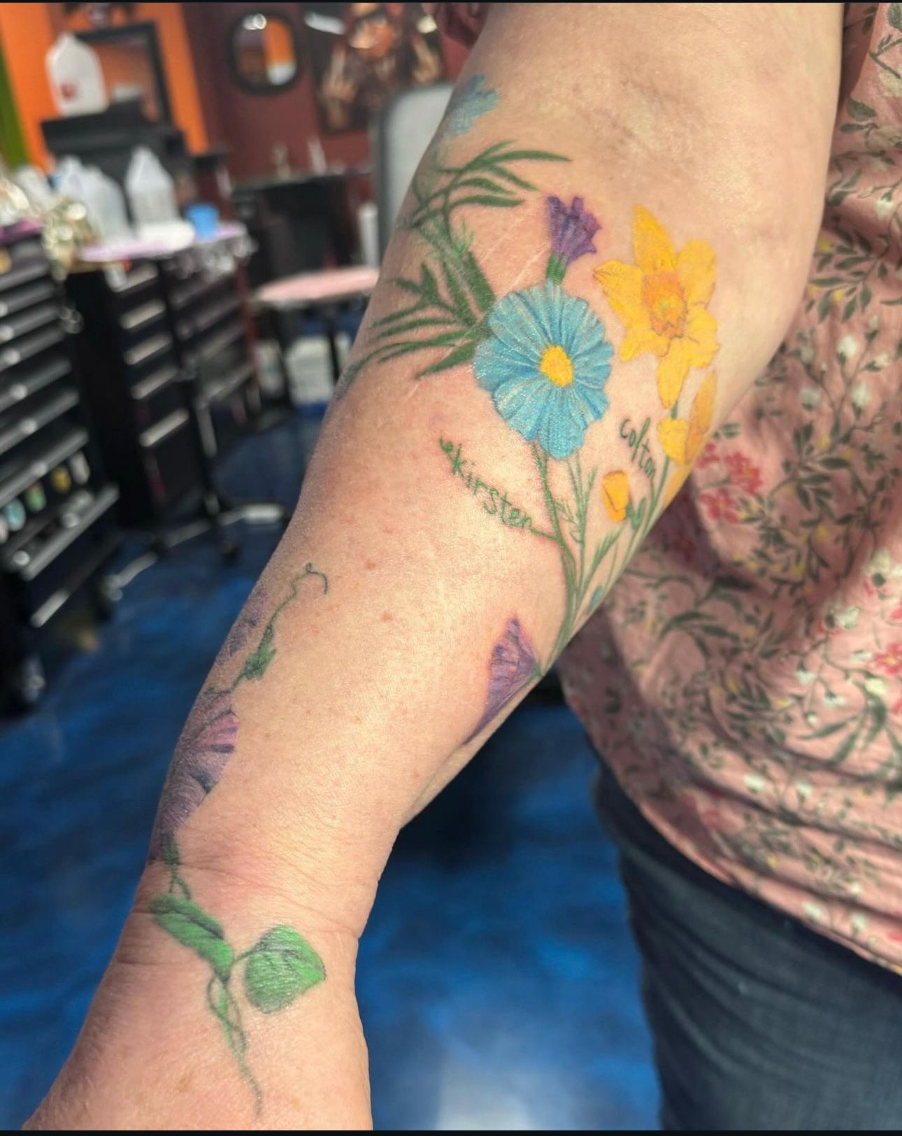 A woman has a tattoo of flowers on her arm