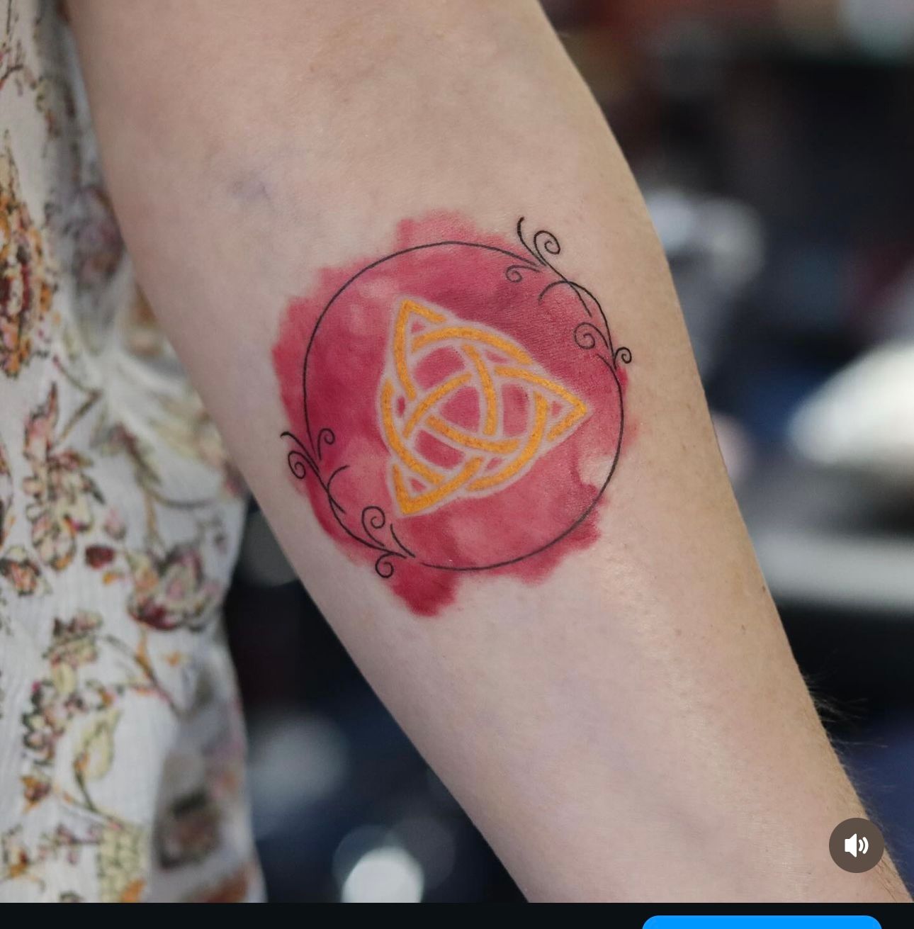 A woman has a tattoo of a celtic symbol on her arm