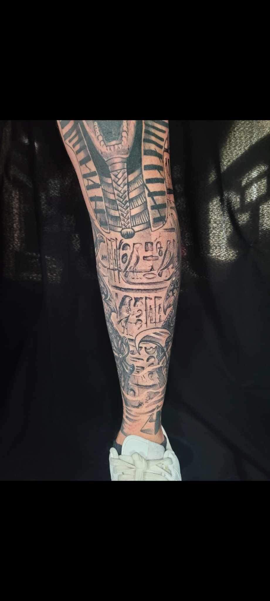 A close up of a person 's leg with a lot of tattoos on it.