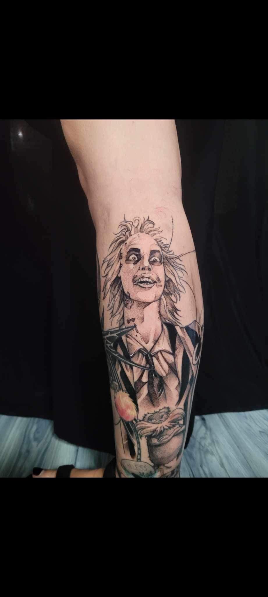 A person has a tattoo of a woman on their leg.