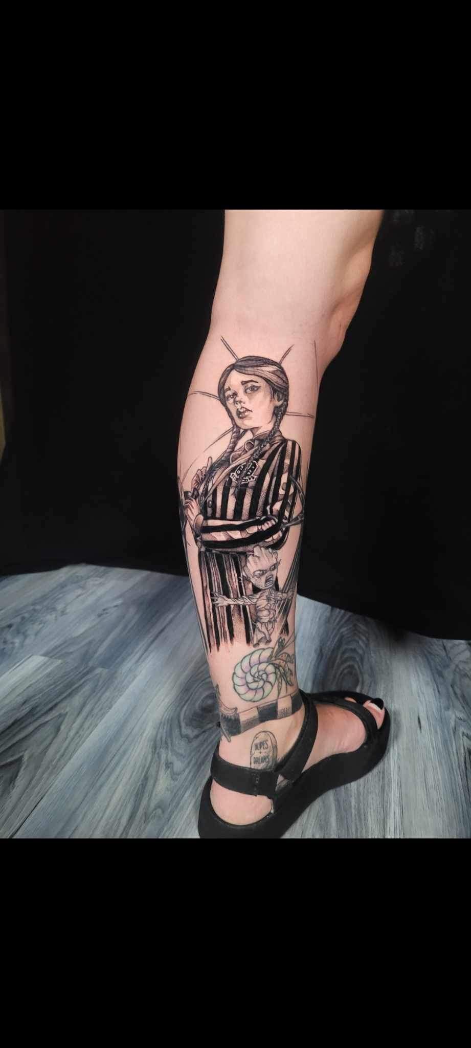 A person has a tattoo of a man on their leg.