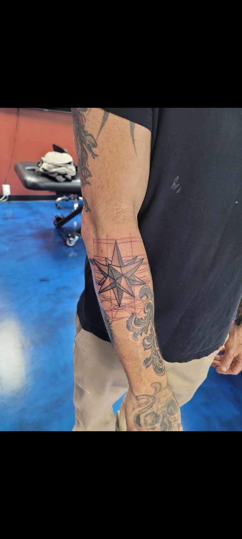 A man is getting a tattoo on his arm.