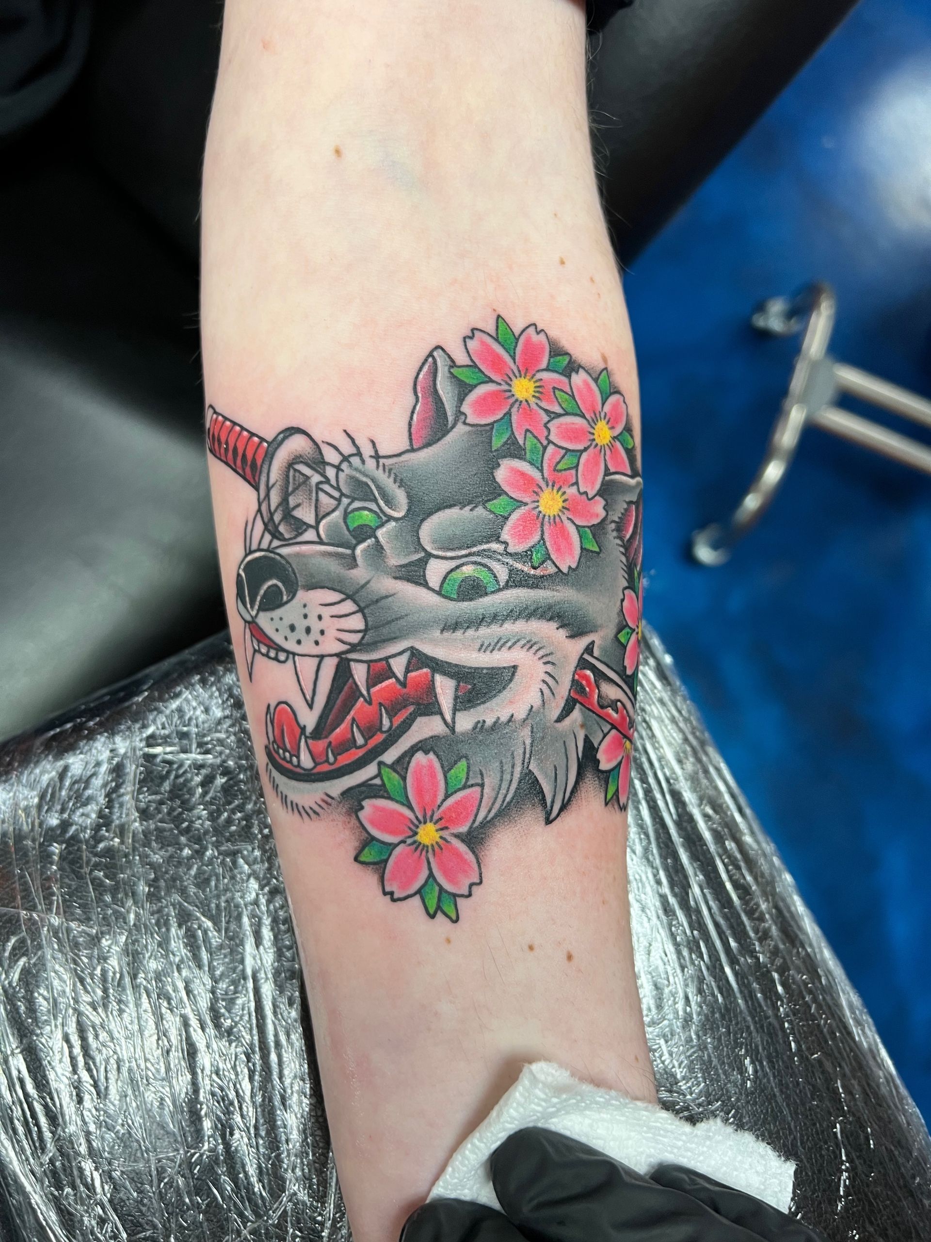 A tattoo of a wolf with flowers on its head