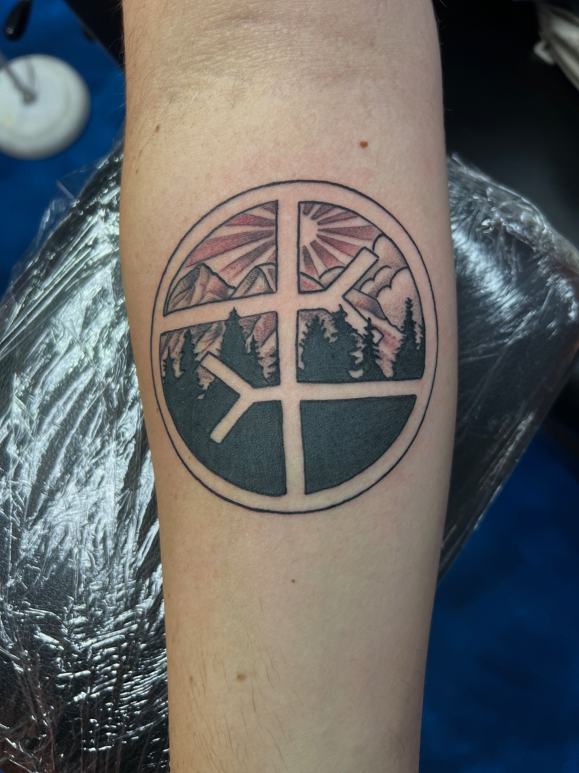 A person has a peace sign tattoo on their forearm