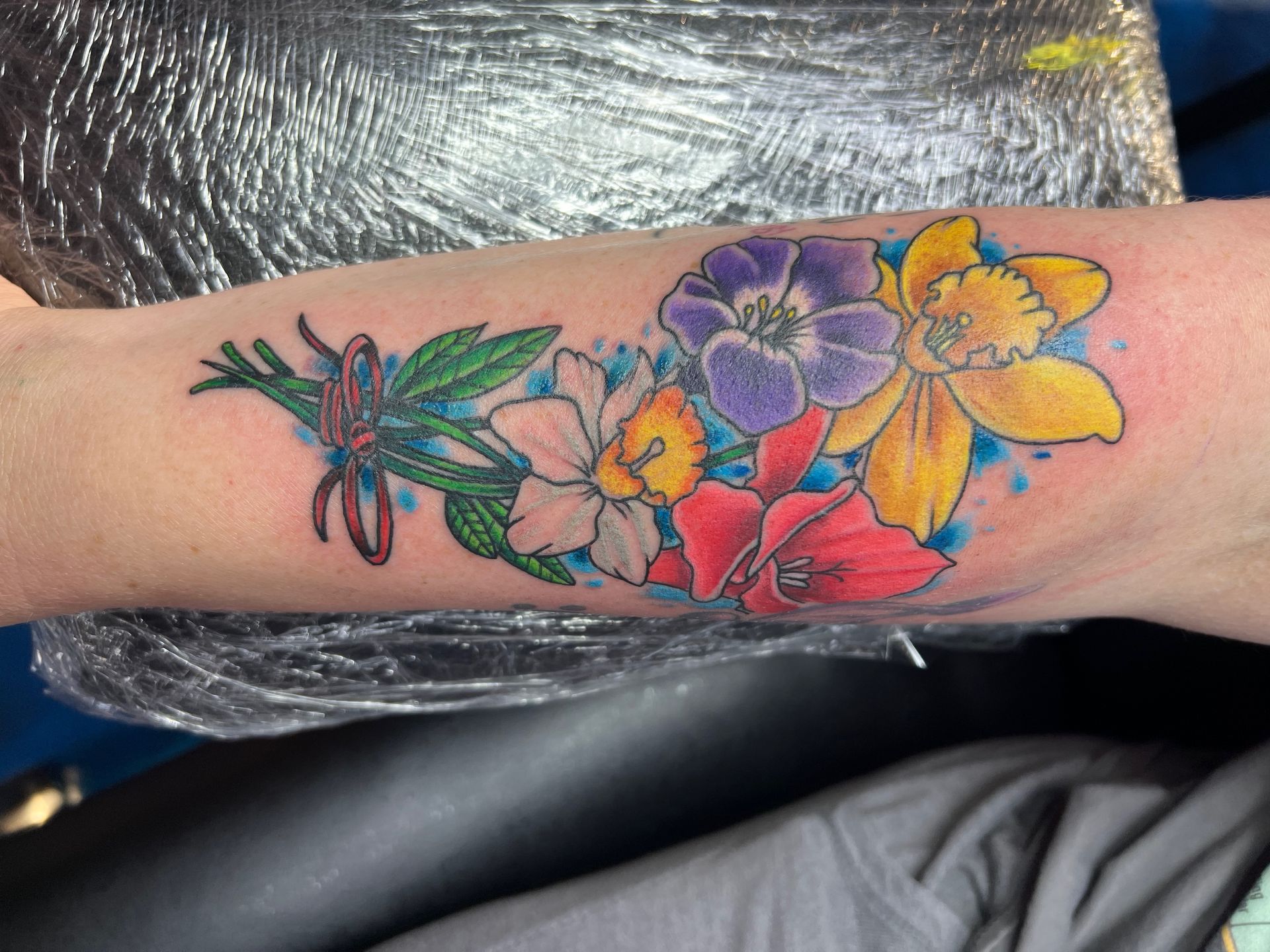 A person has a tattoo of flowers on their arm