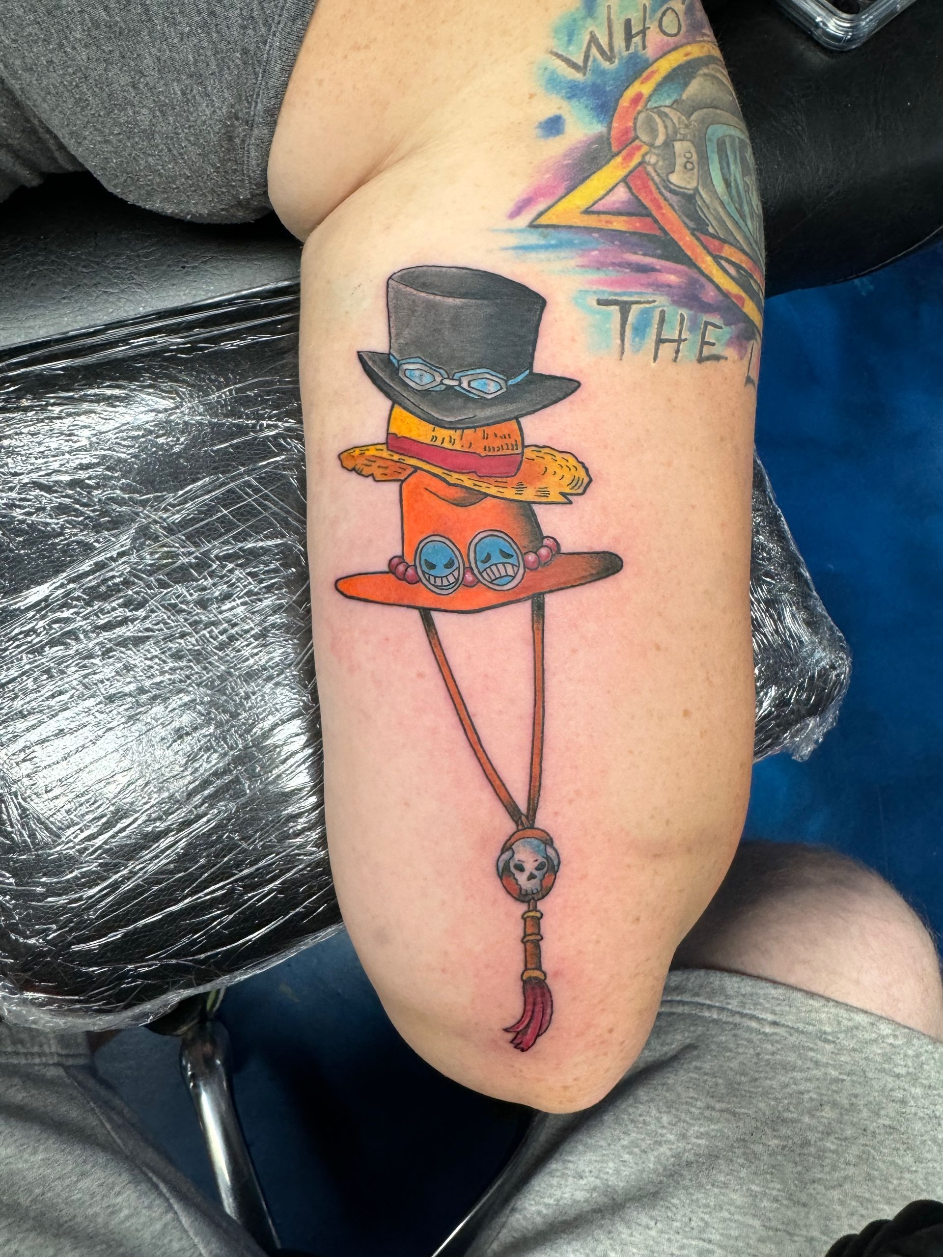 A person has a tattoo of a top hat on their arm