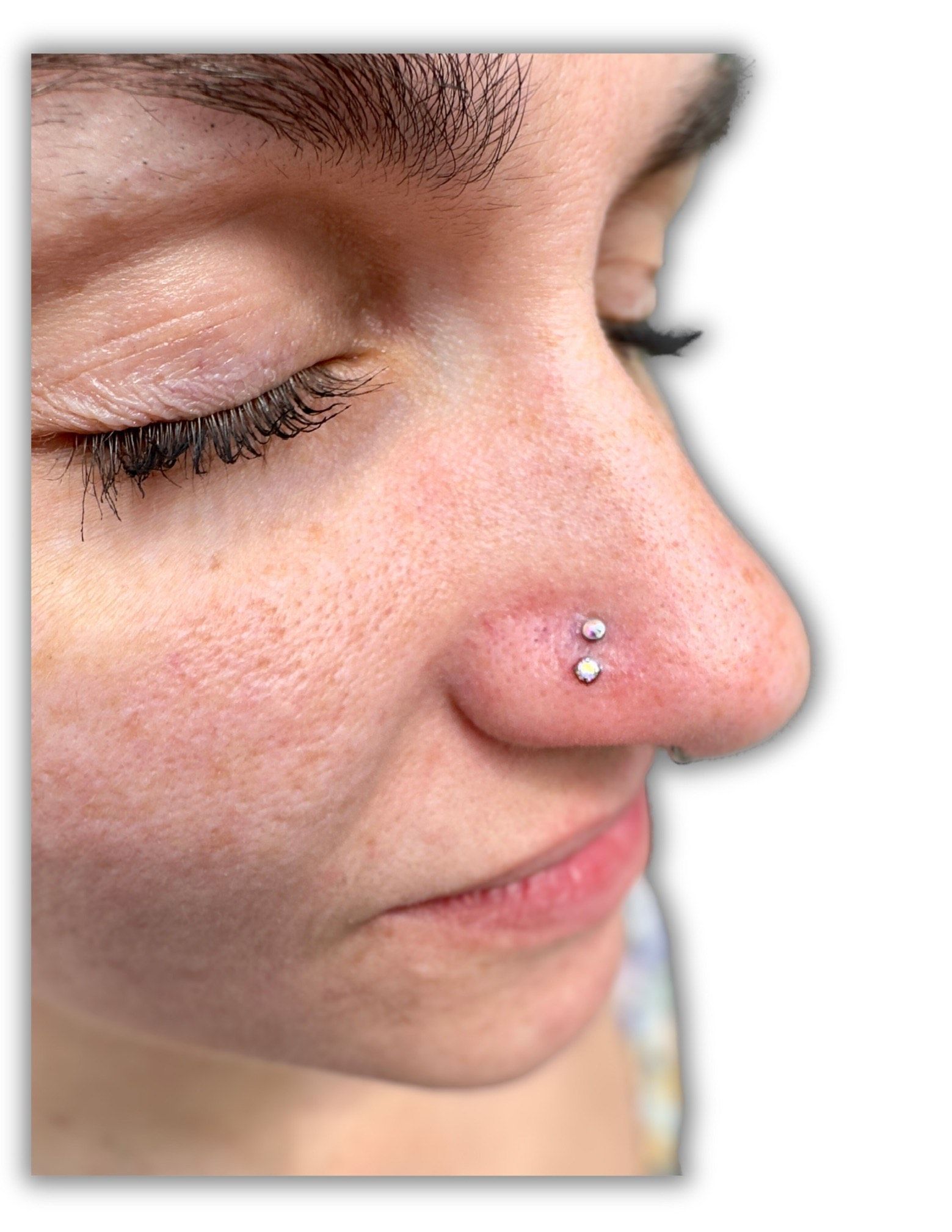 A close up of a woman 's nose with a nose ring.
