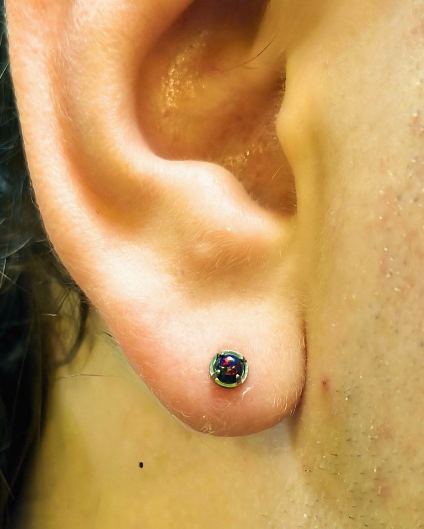 A close up of a person 's ear with a pair of earrings.