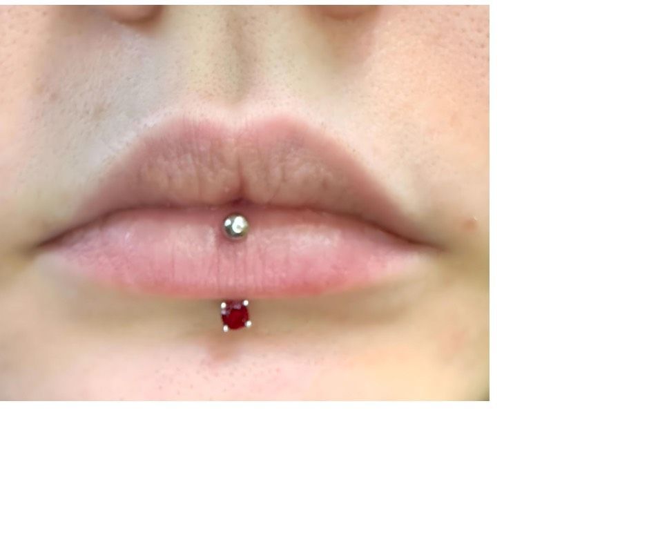 A close up of a person 's lips with a piercing.