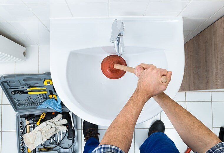 Plumber in Canberra unblocking a drain