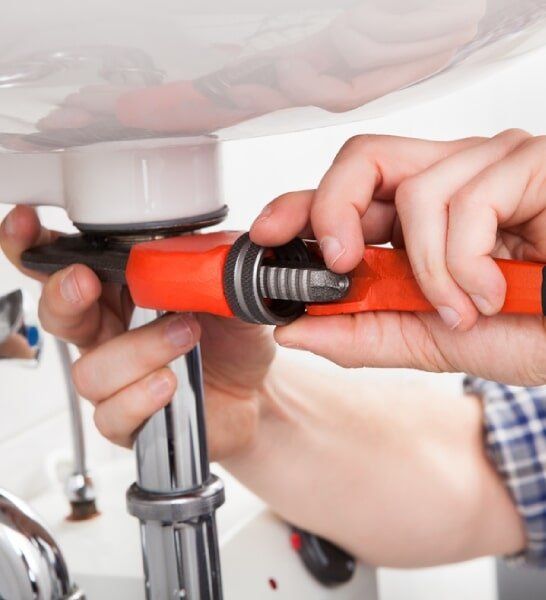 Plumber Repairing A Sink — Plumbing in Canberra, ACT