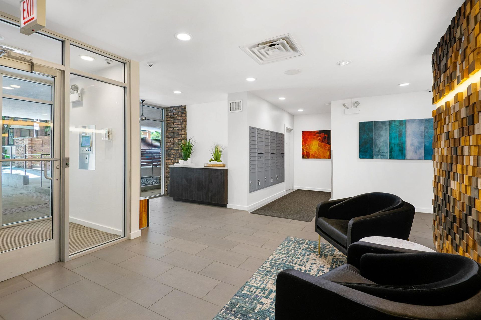 a lobby with chairs and a rug and a glass door