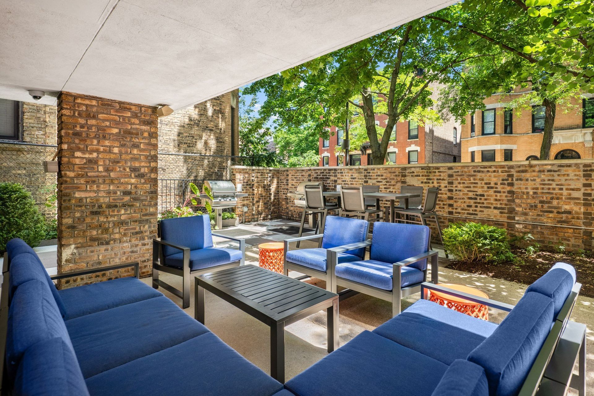 a patio with blue couches and chairs and a table