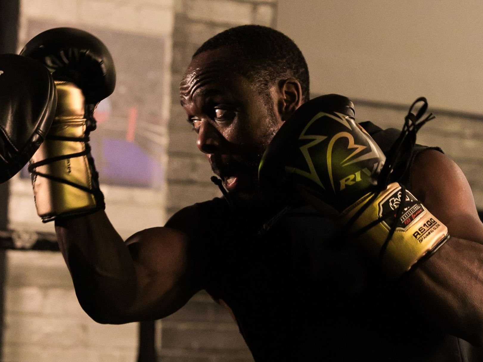 A man is wearing boxing gloves that say everlast on them