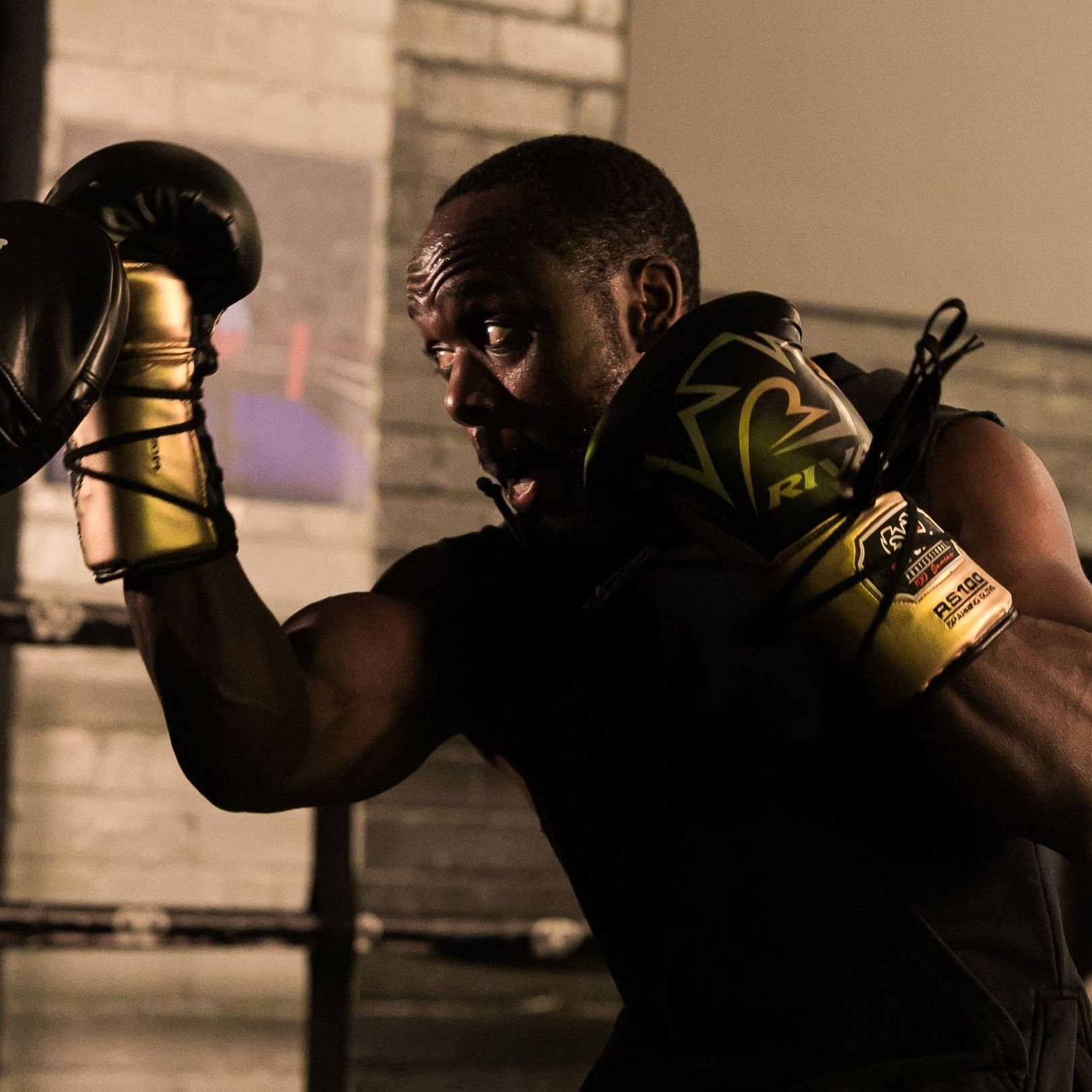 A man wearing boxing gloves with the letter f on them