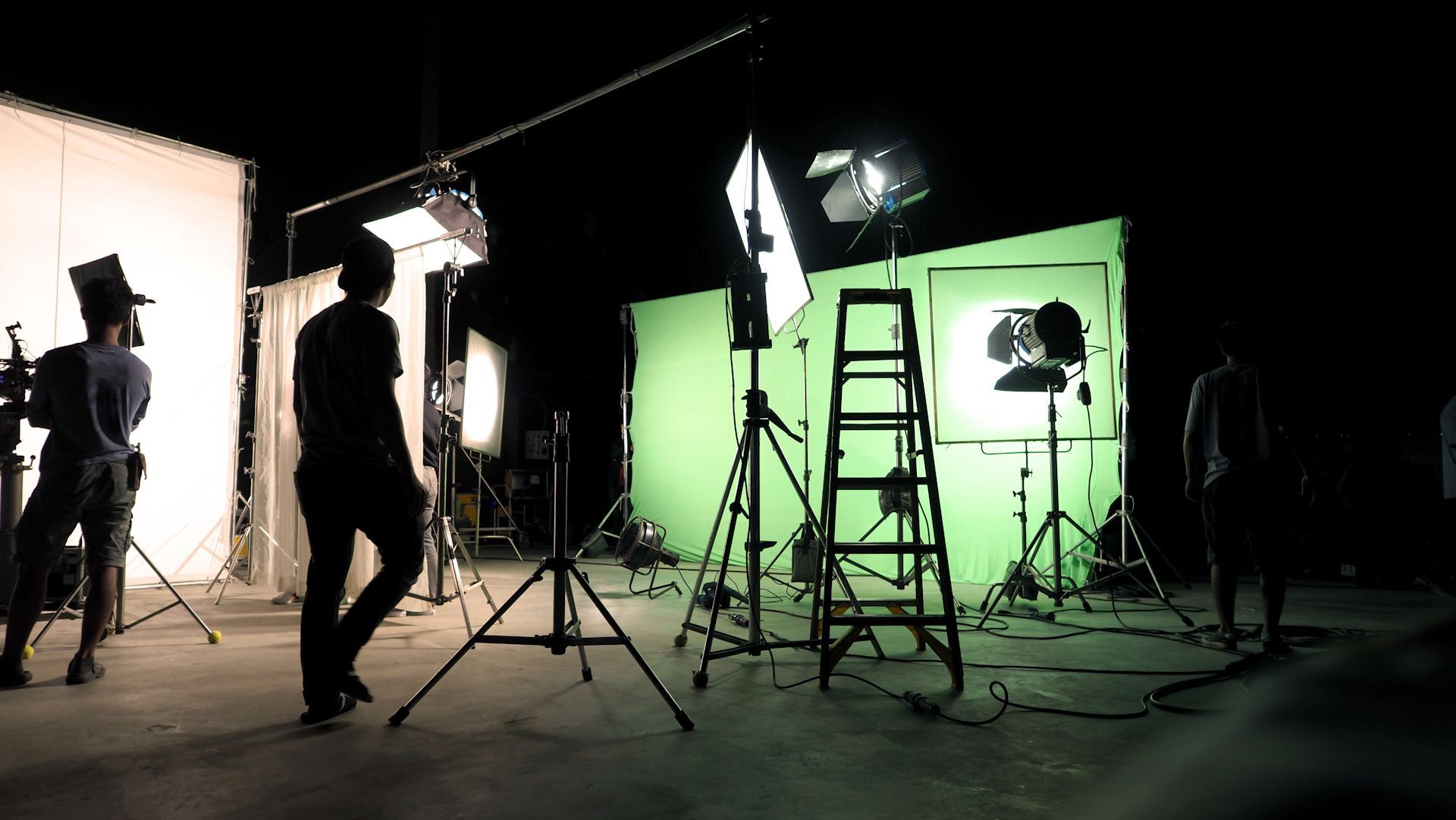 A man is standing in front of a green screen