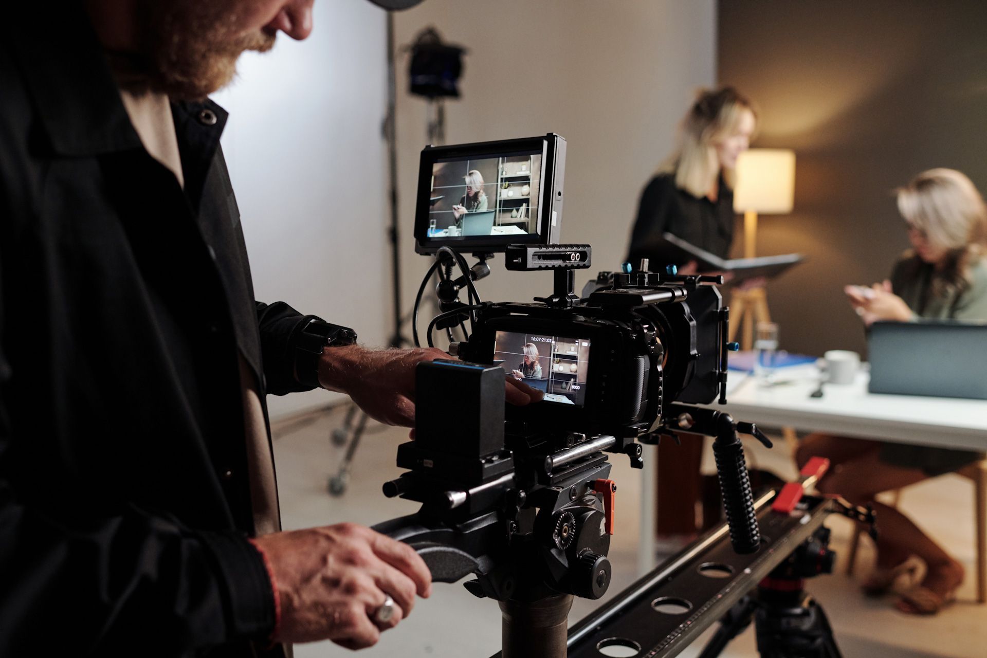 A man is holding a camera in front of a group of people.