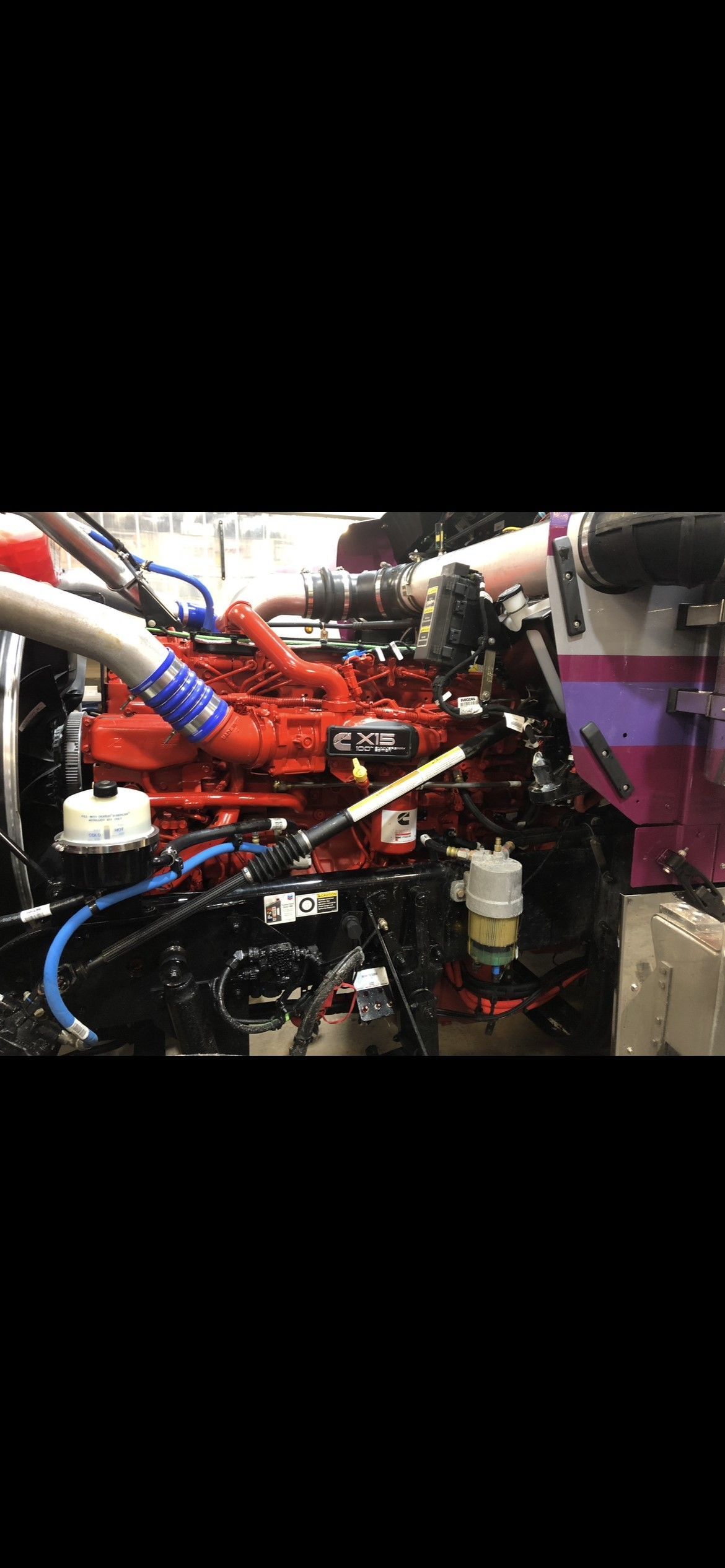 Red engine with blue hoses, against a black background.