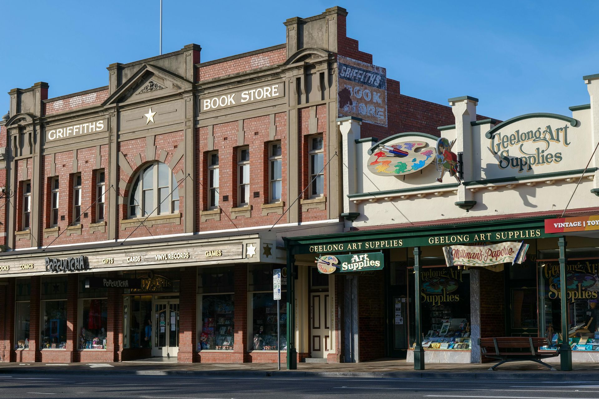 Two-story brick buildings on a street, one reading 