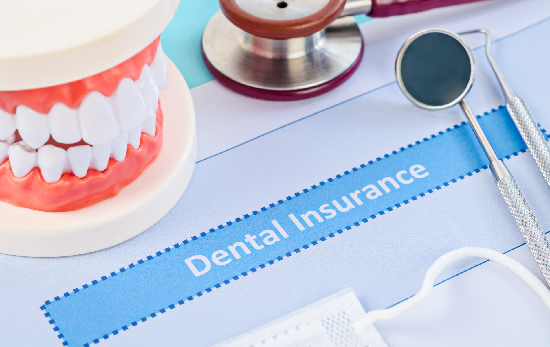 A dental insurance form with a model of teeth , a stethoscope , and dental instruments.