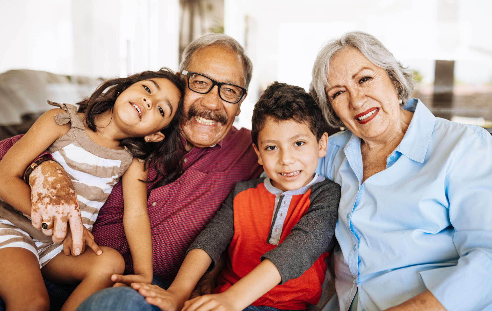 A family is posing for a picture while sitting on a couch.