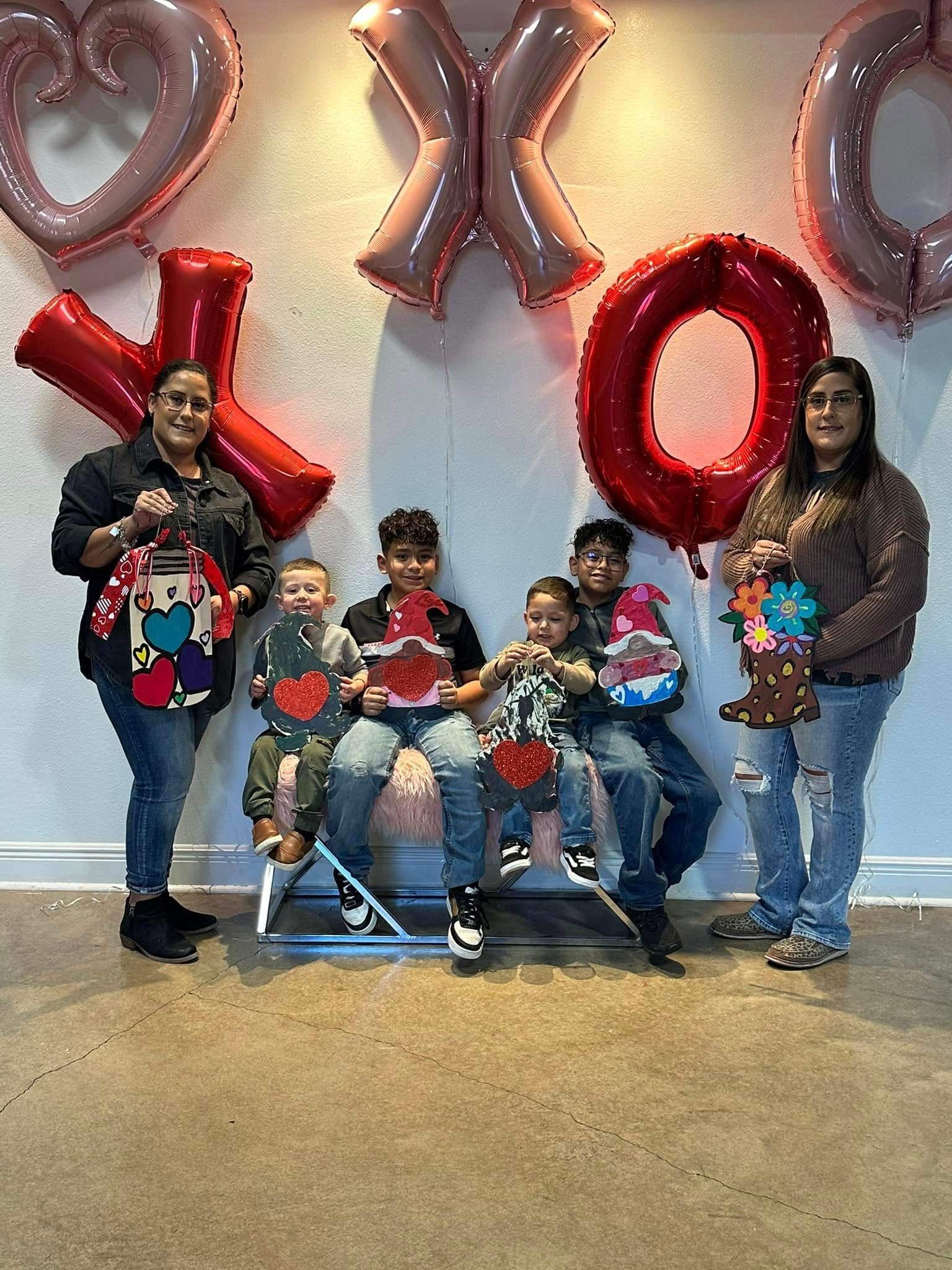 A group of people are posing for a picture in front of balloons.