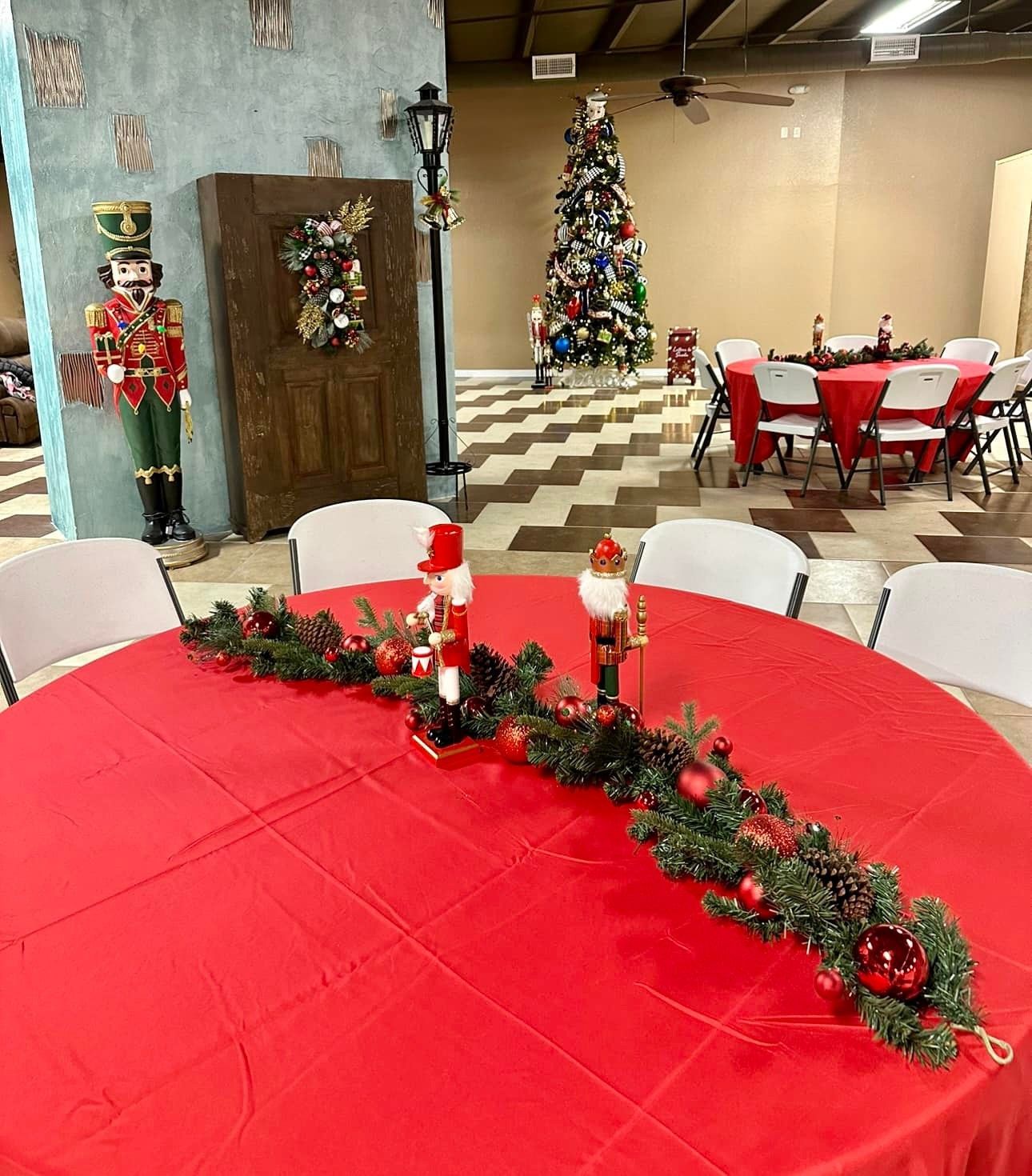 A table with a red tablecloth and christmas decorations on it.