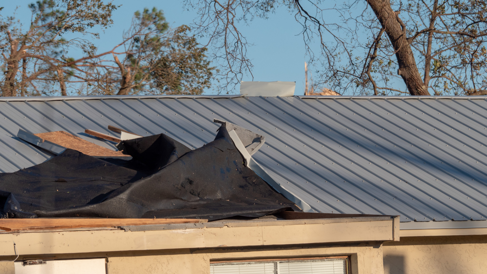 A house with a roof that has been damaged by a storm.