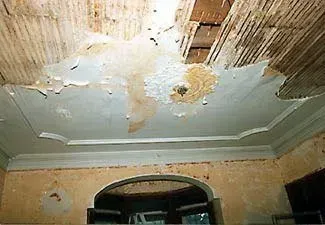 A room with a ceiling that has been damaged by water.