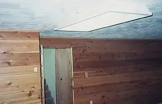 A wooden wall with a door and a ceiling in a room.