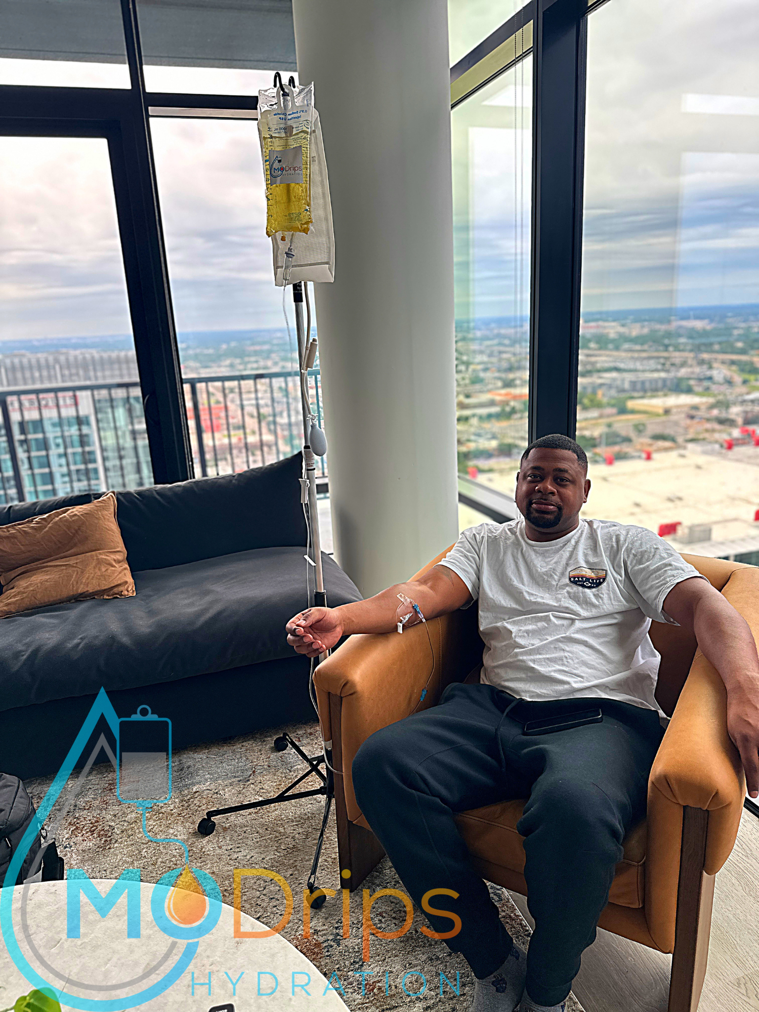 A man is sitting in a chair with an iv in his arm.