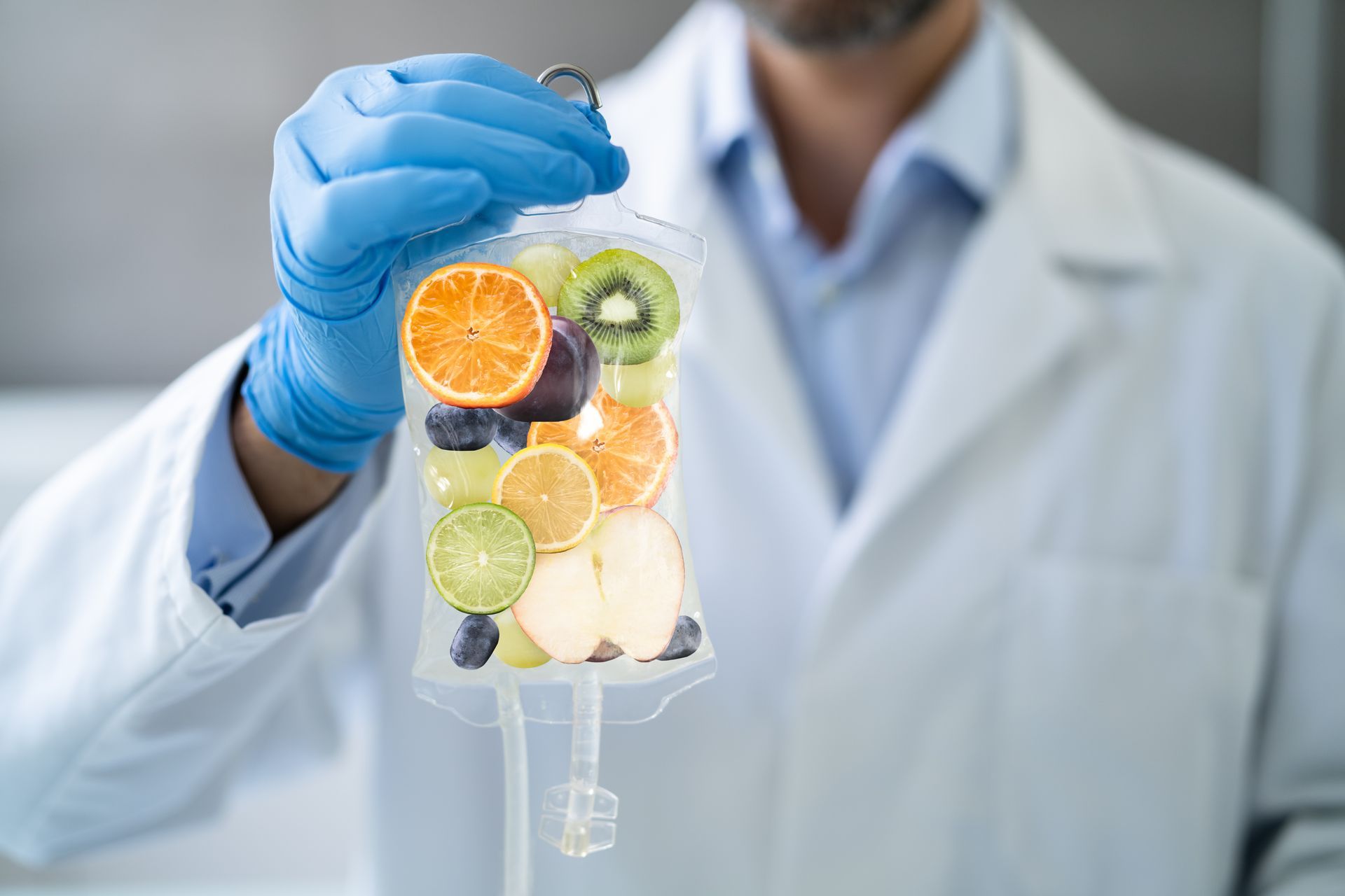 Doctor holding IV bag filled with colorful fruit slices.