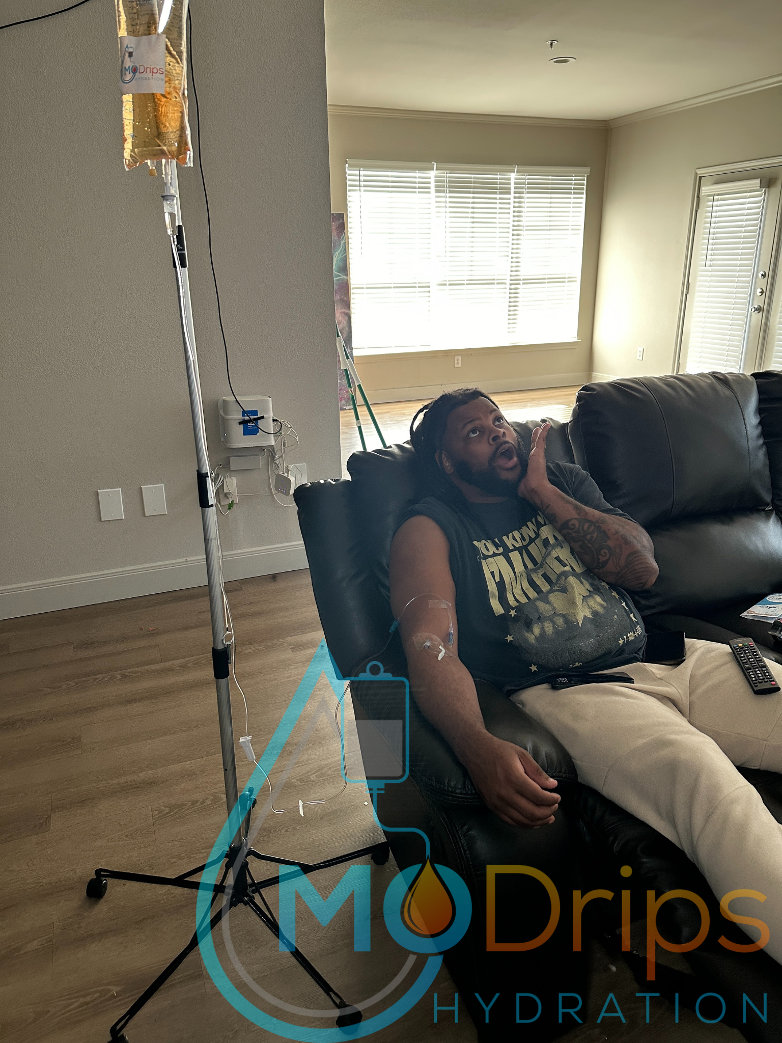 A man is sitting in a chair with an iv in his arm.