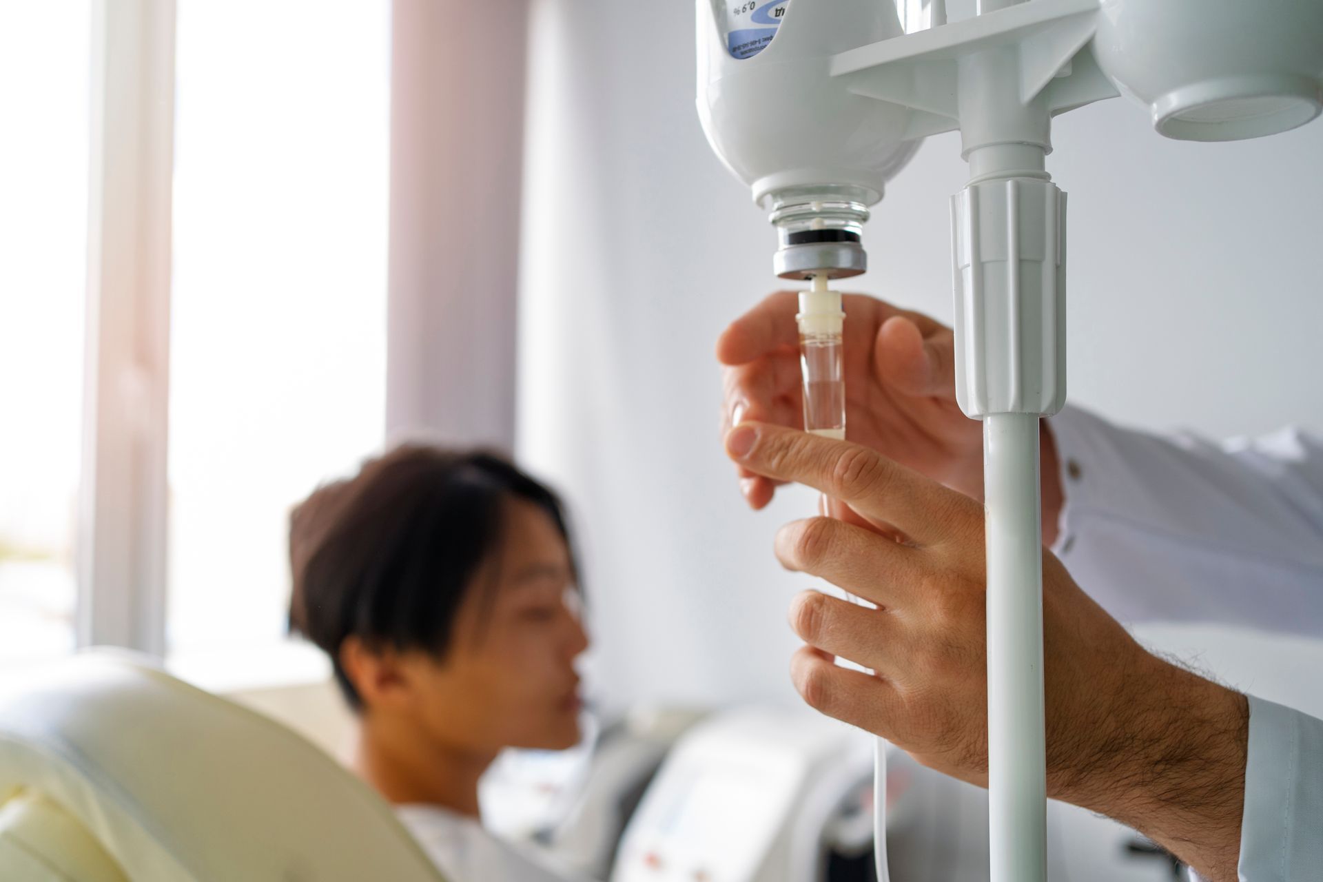 A doctor is giving an injection to a patient in a hospital bed.