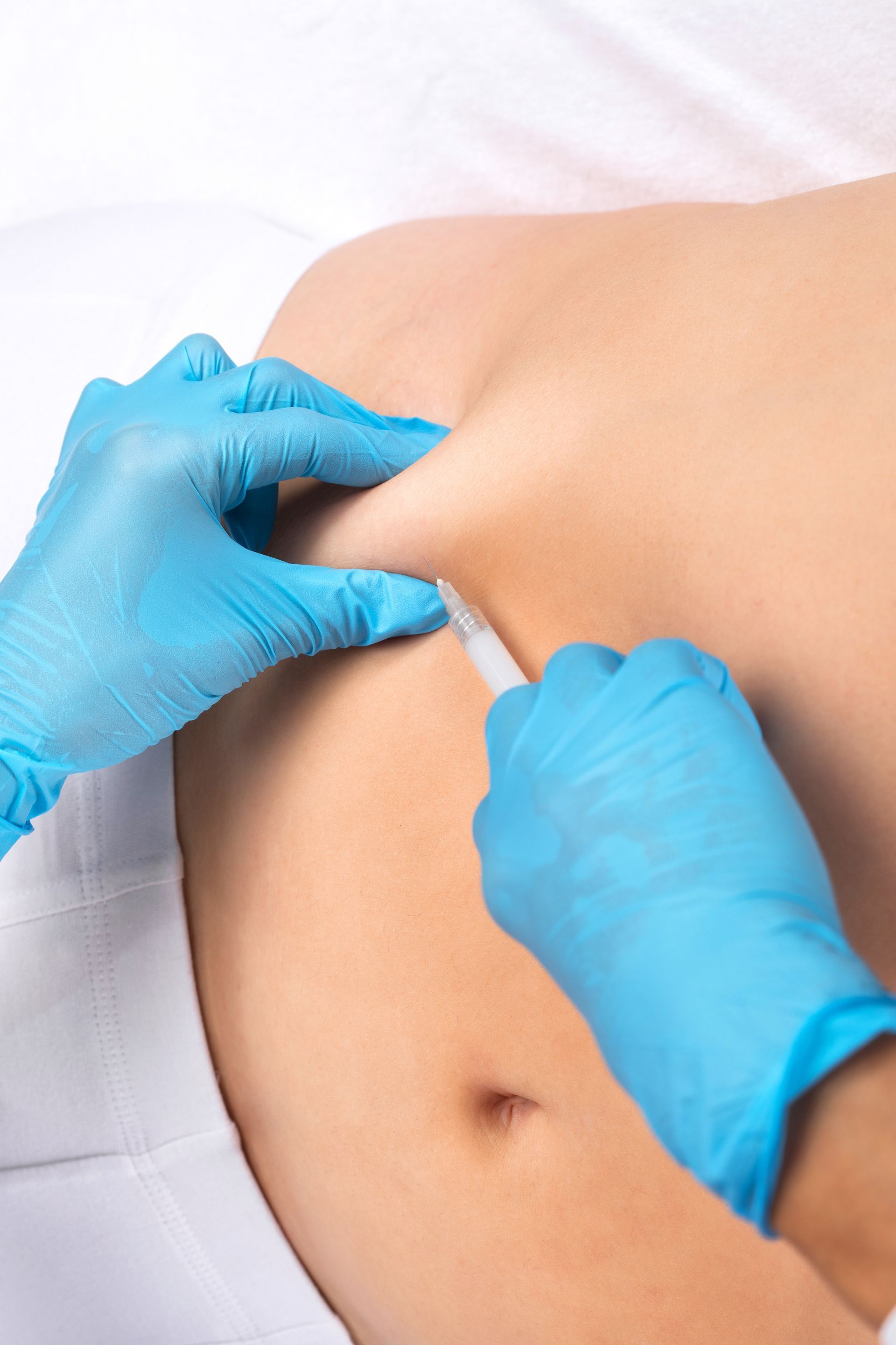 A person is getting an injection in their stomach.