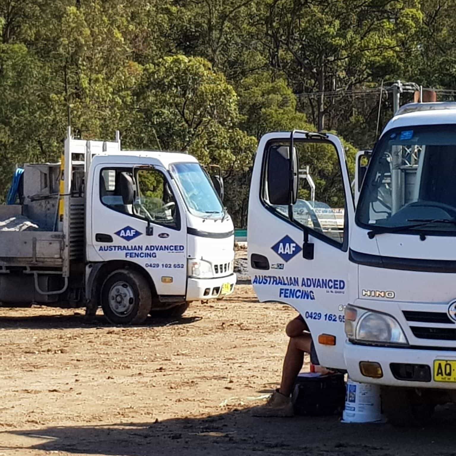 Two Aaf Trucks Are Parked In A Dirt Lot — Australian Advanced Fencing In Port Macquarie, NSW