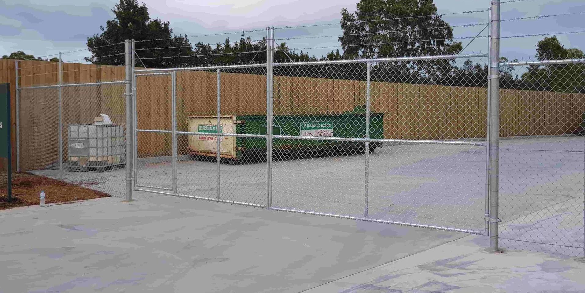 A Chain Link Fence Is Surrounding A Parking Lot — Australian Advanced Fencing In Port Macquarie, NSW