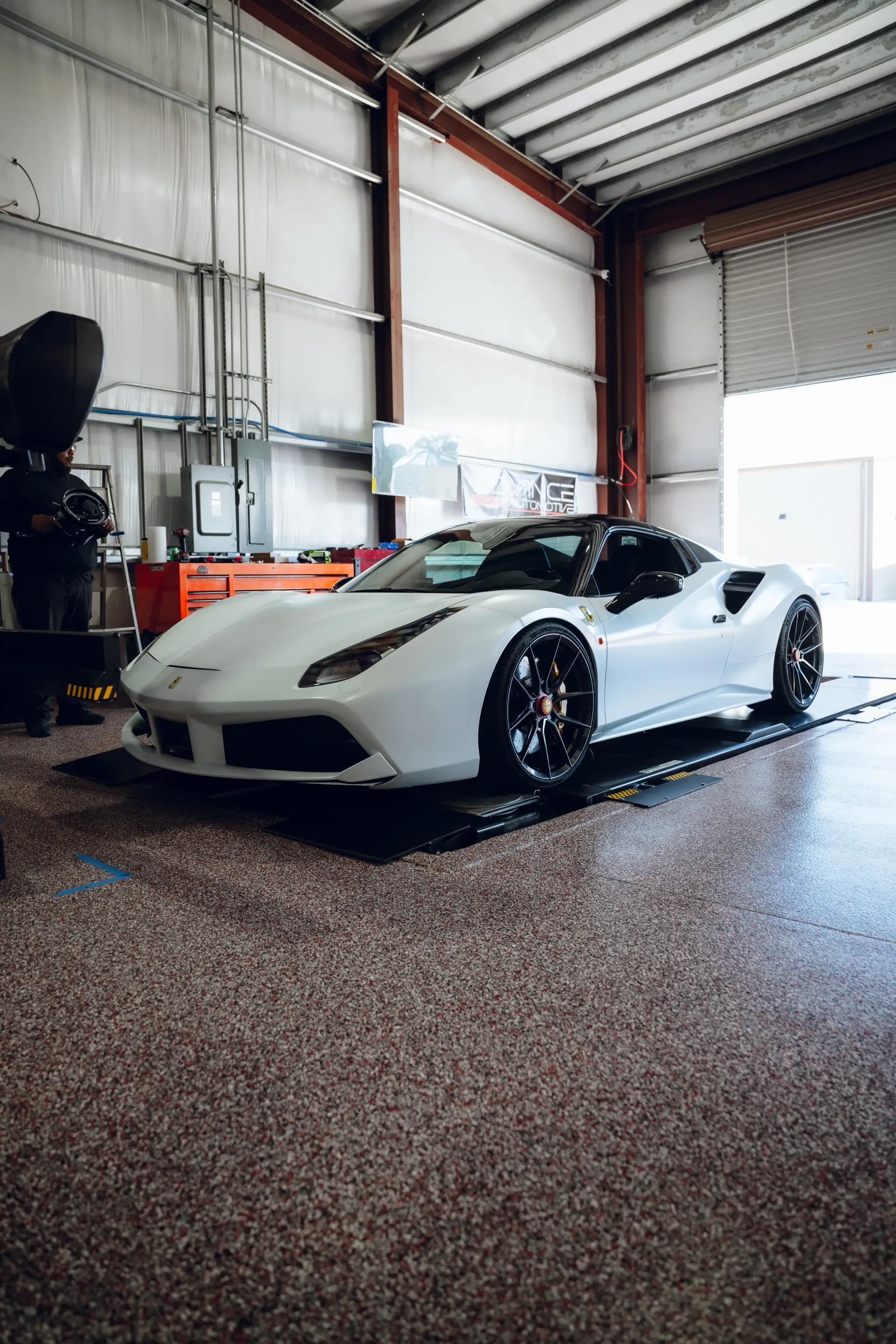 White Ferrari 488 Spider on a dyno in a garage with a black roof. | Advance Automotive