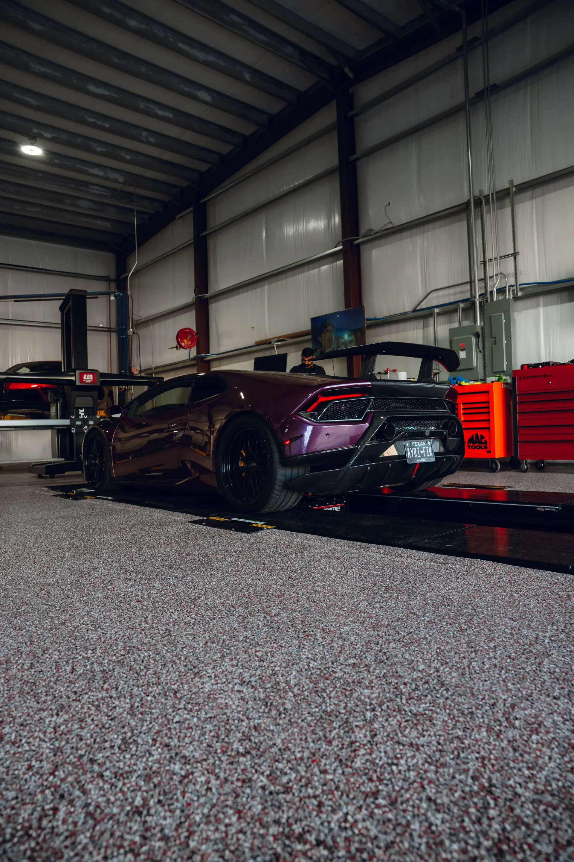 Purple sports car in a garage with a black spoiler and black wheels. | Advance Automotive