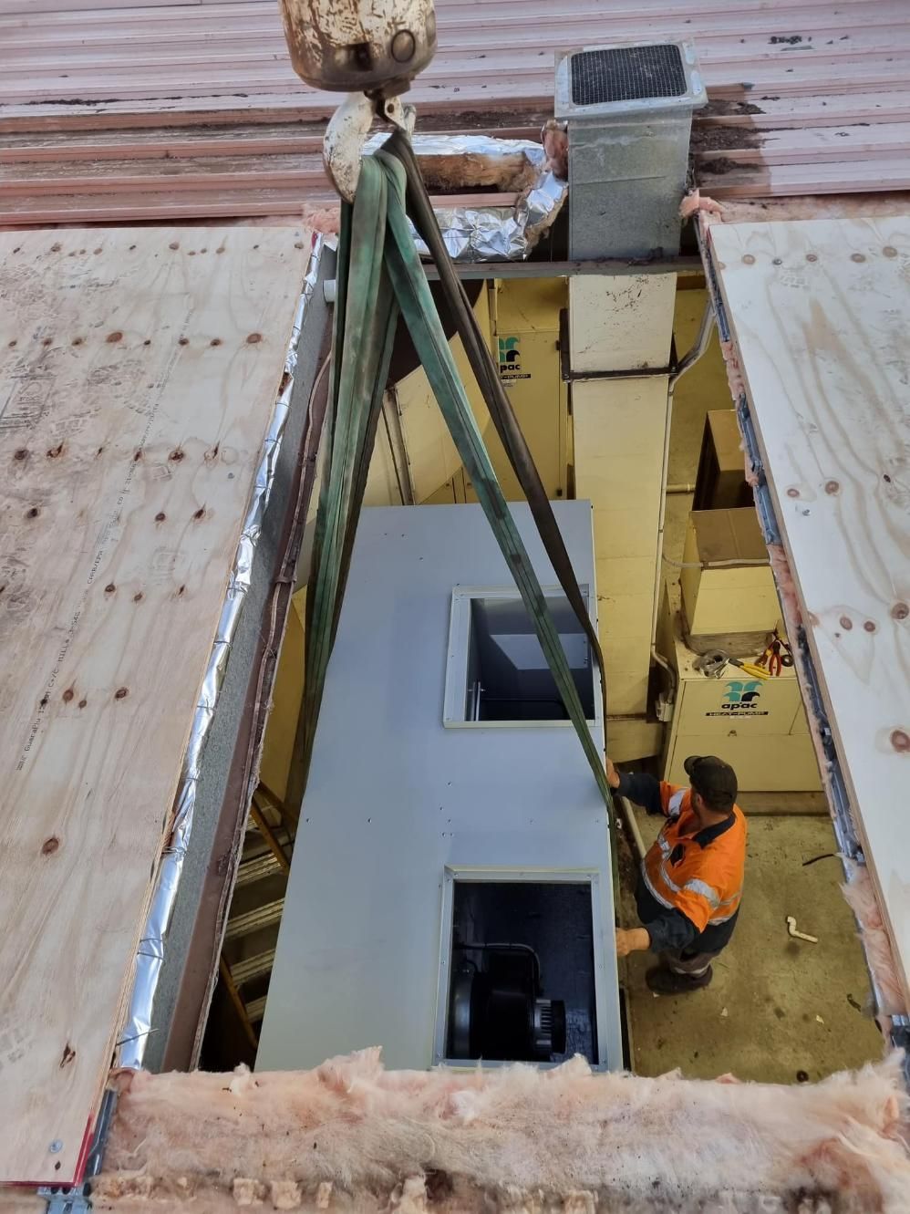 A Man is Working on a Machine in a Room With a Crane — FVS Airconditioning & Electrical Pty Ltd in Ryan, QLD