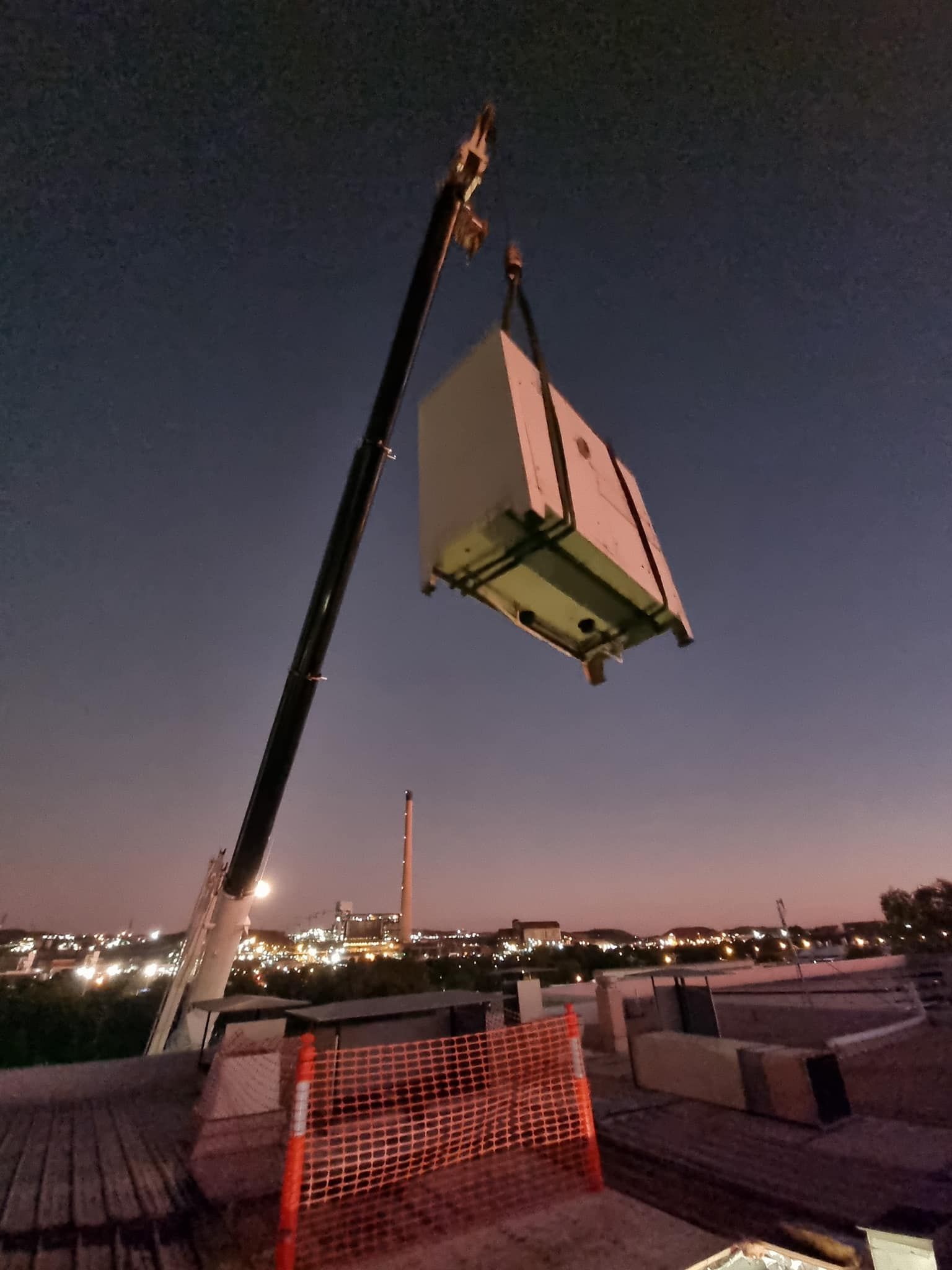 A Crane is Lifting a Box Up Into the Air — FVS Airconditioning & Electrical Pty Ltd in Normanton, QLD